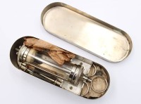 Auktion 373 / Los 15036 <br>ein antikes medizinisches Set wohl hypodermische Glasspritze in Metalldose .