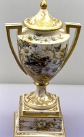 Auktion 373<br>hohe alte Deckelvase, aufwendig bemalt und mit  Goldstaffage, wohl Wiener Historismus oder sp&auml;tes 19.Jhd., kurzer Altriss im Sockel, ansonsten guter Zustand, Bideschild Marke, H-35 cm