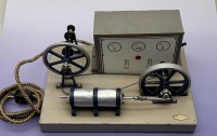 Auktion 373<br>elektrische Steyer-Dampfmaschine aus DDR-Produktion,  orig. Schild, auf Holzplatte, 23x32 cm