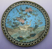 Auktion 373 / Los 15539 <br>Cloisonne Teller der Meiji-&Auml;ra (1868-1912) mit Cloisonn&eacute;-Emaillierung auf Metallgrund (Kupfer oder Bronze).Natur- und Uferszene mit Reihern/Wasserv&ouml;geln,   auf hellblauem Grund. Ornamentaler geometrischer Bord&uuml;renrand in Schwarz und Wei&szlig; mit Metalldrahteinlagen. D-30,5 cm