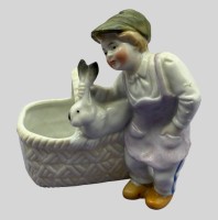 Auktion 374<br>Fig&uuml;rliches Tischv&auml;schen, Junge mit Korb  und Karnickel um 1900, H-12 cm  B-11 cm, Bisquitporzellan,