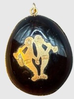 Auktion 375<br>dunkles Bernsteinei oder &auml;hnliches mit Gold-750- (gepr&uuml;ft) Auflage und Montur, 2 Oboen-Spieler eingelegt, ca. 3x2 cm