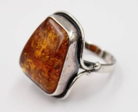 Auktion 376<br>Silberring mit einem cognacfarbenen, trapezf&ouml;rmigen Bernstein in einer glatten 925er-Sterlingsilberfassung.