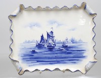 Auktion 376<br>Keramik- bzw. Porzellan-Servierplatte im Delfter Stil mit einem handbemalten, blau-wei&szlig;en Seest&uuml;ck und Segelschiffen sowie einem gerollten, rocailleartigen Rand.
