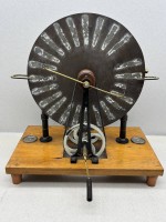 Auktion 376<br>historische Wimshurst-Influenzmaschine (oft auch als Voltana-Maschine bezeichnet), wie sie um 1900 als Lehrmittel im Physikunterricht eingesetzt wurde. H-40 cm, 39x25 cm Platte