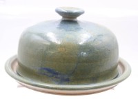 Auktion 369 / Los 9003 <br>gr. K&auml;seglocke, Kunstkeramik, signiert "Livia" ?, H-12cm, Teller D-22cm.