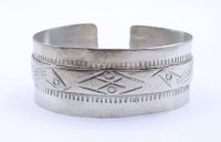 Los  <br>Breiter Silberarmreif aus Silber (gepr.), mit indianischem (?) Muster, Innenseite gestempelt "3", B. 2,7 cm, Ø 5,8 - 6,5 cm, 48 gr., mit Alters- und Tragespuren