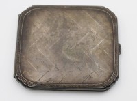 Auktion 500009 / Los  <br>Zigarettenetui, um 1920, Alpacca, innen Ziermonogramm, ungepflegter Zustand, ca. 9,2 x 8,2cm.