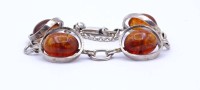 Auktion 333 / Los 1015 <br>Silber Armband mit 4 Bernstein Cabochons, Silber 0.835, L. 17cm, 18,8g.
