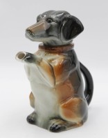 Auktion 334 / Los 9007 <br>Scherzkanne, Dackel, bemalt in Unterglasur, nur Nr. 6703, H-20,5cm.