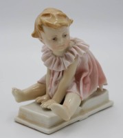Auktion 334 / Los 8022 <br>Figur, ENS Volksstedt, Kind auf Buch, älter, Kleid mehrfach bestossen, ca. H-10,2cm B-9cm.