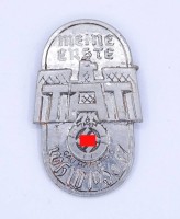 Auktion 334 / Los 7024 <br>WHW Abzeichen "Meine erste Tat" Gau Hamburg 1936/37