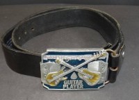 Auktion 500010 / Los  <br>Ledergürtel mit gr. Metallschnalle "Guitar Player" USA, Tragespuren