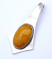 Auktion 336 / Los 1047 <br>Großer Art Deco Anhänger KAY (Christoph Kay Hamburg), Silber 835/000 mit einem Bernstein Cabochon, L. 8,6cm, 21,3g.