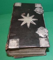 Auktion 336 / Los 3003 <br>"Die Heilige Schrift" 1768, Einband der Zeit mit vioelen Silber-Beschlägen und Schliessen,, Schliessen Innenseite Monogramm und dat. 1771, Alters-und Gebrauchsspuren, Buchrücken lose, H-9 cm, 17x10 cm