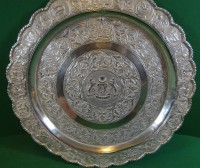 Auktion 336 / Los 11053 <br>Silberplatte (geprüft) Malaysia, aufwendiges Dekor mit Staatswappen, Löwen als Schildhalter, oben kleines Loch (zum Befestigen), D-ca. 30 cm,  284,75 gr.