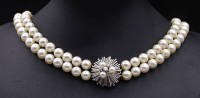 Auktion 337 / Los 1007 <br>2-reihige Perlen Halskette mit Weißgoldverschluss 750/000, Verschluss mit 3 Perlen und 4 Brillanten zus.ca. 0,20ct., L. 45cm, Perlen D. 6,9 - 7,4mm