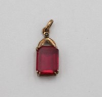 Auktion 338 / Los 1023 <br>Anhänger, Gold um 14ct (gepr.), roter Farbstein, zus. ca. 1gr., L-1,5cm B-0,7cm.