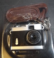 Auktion 338 / Los 16099 <br>kl. Digital-Spion Kamera?, mit 8 GB Speicerkarte von Hama, mit Lederband, ??Kamera 3,5x4 cm