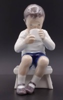 Auktion 339 / Los 8013 <br>Junge trinkt ein ein Glas Milch, - Victor - "Royal Copenhagen", Nr. 418, H. 13,0cm