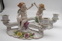 Auktion 339 / Los 8060 <br>Paar figürliche Kerzenständer mit Putti, ein kleiner Abplatzer, Unterseite kurzer AltrissH-17 cm, L-25 cm