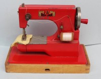 Auktion 339 / Los 12015 <br>Puppen-Nähmaschine "Regina" Blech auf Holz, H-15 cm, 12x22 cm