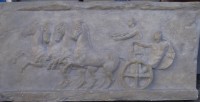 Auktion 339 / Los 15078 <br>gr. Stuckrelief mit altgriechischen Reliefbild eines Streitwagens, verso eingearbeitetes kl. Bronze-Medaillon mit Herstellewr, 42x85 cm (nicht versendbar bzw. nur Speditionsversand)