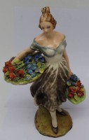 Auktion 341 / Los 9017 <br>Fayence-Figur "Gärtnerin mit 2 Blumenkörben" unleserl. signiert, Italy, minim. Farbabplatzer an Blüten, H-23,5 cm, 19.Jhd.