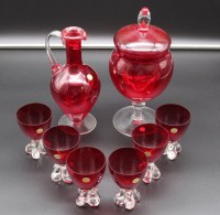 Glas-Set, Murano, rot/klar, Karaffe mit 6 Gläsern (1x bestossen), und Deckeldose auf Stand, Dose ca. H-26,5cm und Gläser 9,6cm.