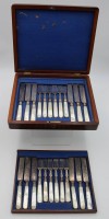 Los 11029 <br>Besteck f&uuml;r 12 Personen in Holzkasten, 19. Jhd., Perlmuttgriffe, Messerklingen ziseliert, versilbert, Kasten mit Altersspuren, Messer L-20,2cm.