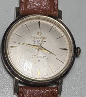 Auktion 348 / Los 2046 <br>flache vintage HAU "Hocks-Alcis Goldcoin" 21 Jewels, Doublee-Gehäuse, Lederband, Tragespuren, Werk läuft