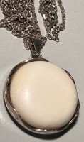 Auktion 359 / Los 1046 <br>835er-Silberkette mit Anhänger, Beincabochon in Silberfassung, L. Kette: ca. 80 cm, Ø Anhänger: 3 cm, zus. 22 gr.