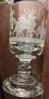 Auktion 364<br>Weinglas auf Stand, dickes Glas,  umlaufend Schliff Wildtiere und Spruch "Dir ist wohl und uns ist besser" H-15 cm