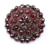 Auktion 365<br>Runde Brosche mit Granate, Nadel aus 14K Gold, wohl Tombak, D-3,5cm, 12,6 gr.