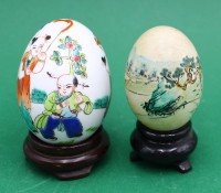 Auktion 365<br>2x handbemalte chinesische Eier, auf Holzstand, 1x echte Eierschale H- 6cm, 1x Porzellan-Ei H- 8cm (Höhe je ohne Stand)