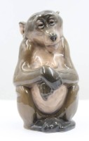 Auktion 367<br>Sitzender Pavian, Royal Copenhagen, Entw. Niels Nielsen 1913, Modellnr. 1444, staffiert in Unterglasurfarben, H-13 cm, ein Schleifstrich
