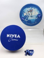 Auktion 368 / Los 15142 <br>Werbekonvolut, Nivea, gr. Wanduhr (Eigenbau?) und gr. runde Blechdose, ca. D-33cm H-8cm