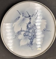 Auktion 369 / Los 9047 <br>Keramik-Untersetzer mit Metall-Montur, Traubendekor, D-15 cm