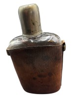 Auktion 369<br>gr. Flachmann, Glas mit Lederh&uuml;lle, eine Naht offen, abschraubbarer Becher, H-20 cm