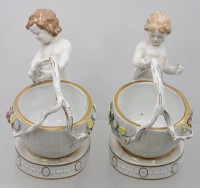 Auktion 369 / Los 8207 <br>Paar grosse Salieren mit Kinderfiguren, "Schierholz" Plaue, aufgesetzte Bl&uuml;ten,  kl. Abplatzer, H-ca. 19 cm