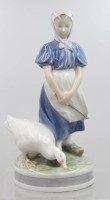 Auktion 375<br>G&auml;nsemagd, Royal Copenhagen, Entw. Christian Thomsen, u. sign., Modellnr. 527, polychrom bemalt in Unterglasurfarben, auf rundem Sockel, H- 23 cm, Brandfehler am Fuss