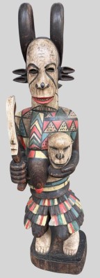 Auktion 375<br>Ikenga-Figur der Igbo  (Nigeria) aus Holz, mit schädelartigem Gesicht und gehörntem Hut, hält in der rechten Hand ein gebogenes Schwert und in der linken einen menschlichen Kopf; bunt bemalt. H-115 cm, 20 kg [1]