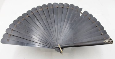 Auktion 375<br>antiker schwarzer Faltfächer mit dunklen Lamellen und einem filigranen silberfarbenen Ornament (1x fehlt), eine Lamelle beschädigt, L-26,5cm [1]