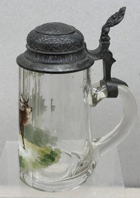 Auktion 376<br>Bierkrug mit Zinndeckel, aussen und innen umlaufend beschriftet und dat. Mai 1900, handbemalt mit Hirsch, langer Spannungsriss. aber noch dicht und benutzbar, H-19 cm, 0,5 L [1]