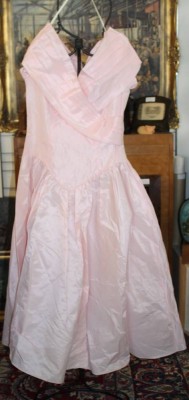 Auktion 376<br>ein rosafarbenes Vintage-Ball- oder Abendkleid (Stil der 1950er- bis 1980er-Jahre) mit einem V-förmig gesenkten Taillenbund und einem überkreuzten schulterfreien Ausschnitt von Loralie USA. [1]