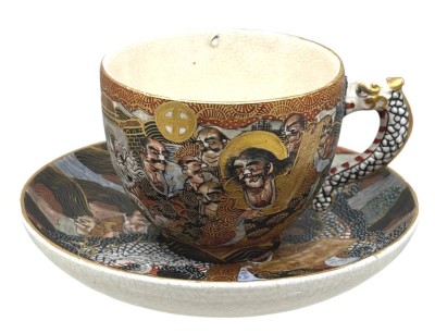 Auktion 376<br>Satsuma Tasse mit U.T., Japan, Rand mit Chip,  farbig und gold gemalter figuraler Dekor von Unsterblichen und Drachen, Bodenmarken [1]