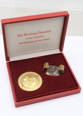 Auktion 376<br>DDR-Ehrengeschenk-Set für eine 30-jährige Dienstzeit in den Organen des Ministeriums des Innern, Medaille und RUHLA Quarz (Werk nicht geprüft), Uhr in getragener Erhaltung (D-3,7cm) [1]