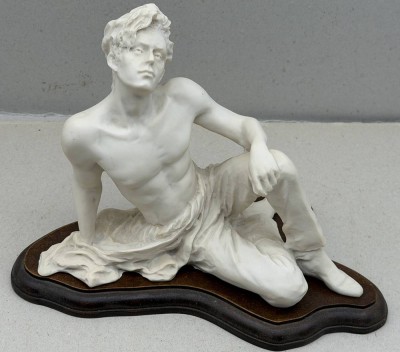 Auktion 376<br>Figur eines sitzenden Jünglings auf Holzbrett,Kunstharz,  H-24 cm, L-30 cm [1]