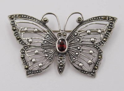 Auktion 348<br>925er Schmetterlingsbrosche, filigran gearbeitet, Markasiten und wohl Granat, 8,2gr., 3 x 5cm. [1]