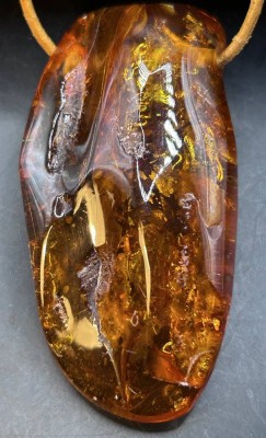 Auktion 350<br>Lederband mit grossen Bernstein-Anhänger mit Einschlüssen, 7,5x4x2 cm, 39,1 gr. [1]
